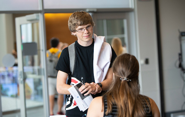 a young man listens to a woman speaking to him